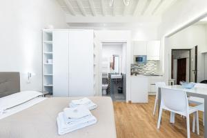 een witte kamer met een bed en een tafel en stoelen bij Emanuele's house in Florence