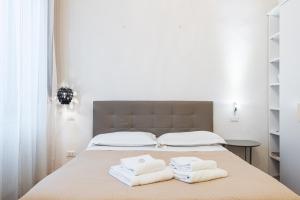 een slaapkamer met een bed met twee handdoeken erop bij Emanuele's house in Florence