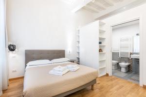 een witte slaapkamer met een bed en een badkamer bij Emanuele's house in Florence