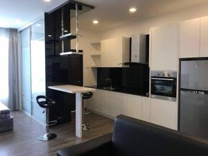 een keuken met zwart-witte kasten en een tafel bij Cheras Romantic Studio House with free Netflix and wifi in Kajang
