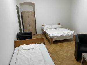 a room with two beds and two chairs at easybook-in in Vienna