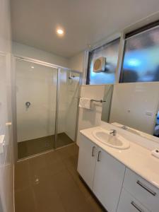 a bathroom with a shower and a sink and a mirror at Kaloha Holiday Resort Phillip Island in Cowes