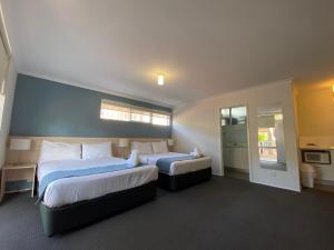 a hotel room with two beds and a window at Kaloha Holiday Resort Phillip Island in Cowes