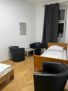 um quarto com duas camas e duas cadeiras e mesas em easybook-in em Viena