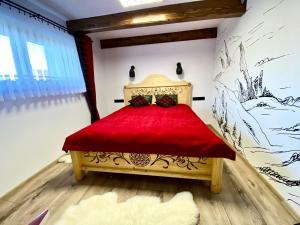 um quarto com uma cama vermelha num quarto em Domek Góralski na Ubocy z jacuzzi em Białka Tatrzanska