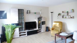 a living room with a television and a chair at Ferienhaus im Grünen in Harztor