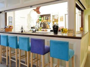 a bar with blue stools in front of a counter at Hazel in Thornbury