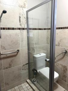 e bagno con servizi igienici e porta doccia in vetro. di 81 on Groenewoud a Città del Capo Altre 4 foto