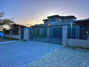 a fence in front of a house with a driveway at 81 on Groenewoud in Cape Town