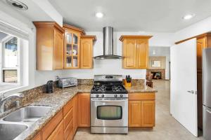 a kitchen with wooden cabinets and a stove top oven at Large Family Home - Only 20 mins from Disneyland in Fullerton