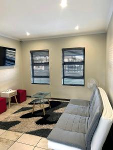 un soggiorno con un divano e un tavolo di 81 on Groenewoud a Città del Capo