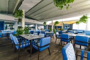 une salle à manger avec des chaises et des tables bleues dans l'établissement db Seabank Resort + Spa All Inclusive, à Mellieħa