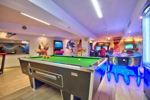 a room with a pool table and arcade games at db Seabank Resort + Spa All Inclusive in Mellieħa