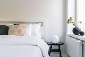Biała sypialnia z białym łóżkiem i stolikiem. w obiekcie Spacious 1 BR with a central location w Helsinkach