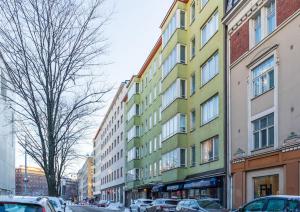 żółty i zielony budynek przy ulicy miejskiej w obiekcie Spacious 1 BR with a central location w Helsinkach