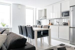 biała kuchnia z białym stołem i krzesłami w obiekcie Spacious 1 BR with a central location w Helsinkach
