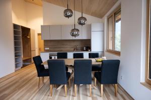 uma cozinha e sala de jantar com uma mesa de madeira e cadeiras em am Greben Apartments drei - vier - fünf em Bezau
