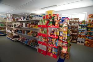 un pasillo de tienda con estanterías de comida y aperitivos en Happy Camp Mobile Homes in Camping Karavomilos Beach, en Sami