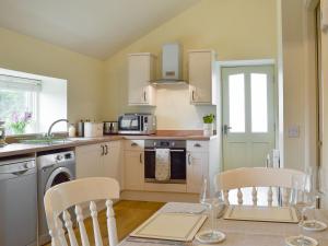 a kitchen with a table with chairs and a microwave at Alphin Apartment in Greenfield