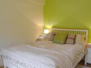 a bedroom with a white bed with a green wall at Alphin Apartment in Greenfield