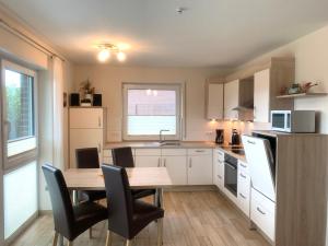 a kitchen with a wooden table and chairs and a table and a kitchen with at Backbord in Horumersiel