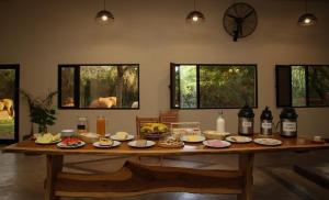 une table remplie de nourriture et de bouteilles de vin dans l'établissement Hostería Jasy, à Colonia Carlos Pellegrini