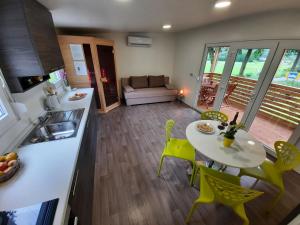 a kitchen and a living room with a table and chairs at Chalet and Apartment Žonir with SAUNA in Kobarid
