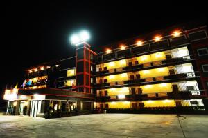 a large building with a clock tower at night at PT Grand Hotel in Ban Tha Makham
