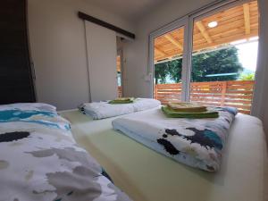 two beds sitting in a room with a window at Chalet and Apartment Žonir with SAUNA in Kobarid