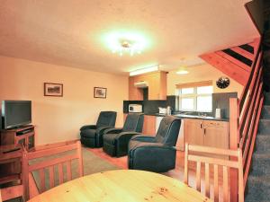 sala de estar con sillas, mesa y cocina en Yarlington Mill, en Ledbury