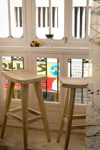a table and two stools in front of a window at Apartments Holidays2Malaga City Center in Málaga