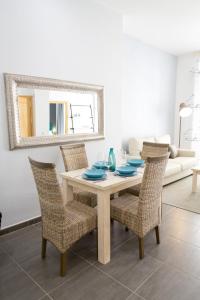 a dining room table with chairs and a mirror at Apartments Holidays2Malaga City Center in Málaga
