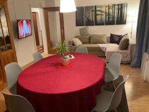 una mesa roja y sillas en la sala de estar. en Ferienwohnung zur Alten Schmiede, en Lenzkirch