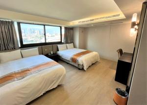 una camera d'albergo con due letti e una grande finestra di Ren Mei Fashion Hotel a Taichung