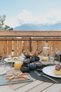 einen Tisch mit Speisen und Getränken auf einer Terrasse in der Unterkunft Aïda Hôtel & Spa - "Adults Only" Relais & Châteaux in Crans-Montana
