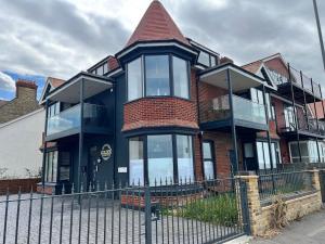 a house with a fence in front of it at The Seafront Apartment - Westbrook Bay Beach - By Goldex Coastal Breaks in Kent