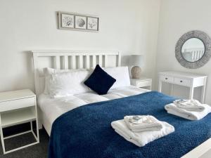 a bedroom with a bed with towels on it at The Seafront Apartment - Westbrook Bay Beach - By Goldex Coastal Breaks in Kent