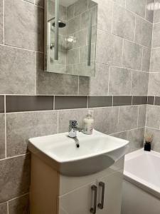 a bathroom with a sink and a mirror at The Seafront Apartment - Westbrook Bay Beach - By Goldex Coastal Breaks in Kent +9 photos