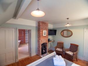 a living room with a brick fireplace and chairs at Red Cottage B&B in Rye