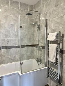 a bathroom with a shower and a bath tub at The Seafront Apartment - Westbrook Bay Beach - By Goldex Coastal Breaks in Kent