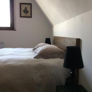 a bedroom with a bed with two lamps and a window at La VILLA en BAIE in Le Crotoy