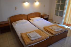 a bedroom with two beds with towels on them at Philippos Hotel in Kassiopi