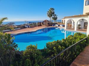 a swimming pool with the ocean in the background at Capistrano Village, Casa Halo in Nerja