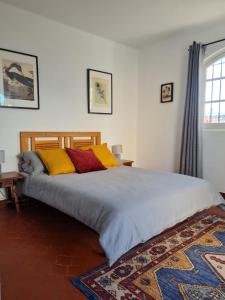 a bedroom with a large bed with yellow and red pillows at Capistrano Village, Casa Halo in Nerja