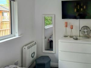une chambre blanche avec un radiateur et un miroir dans l'établissement The Hideaway, à Otterburn