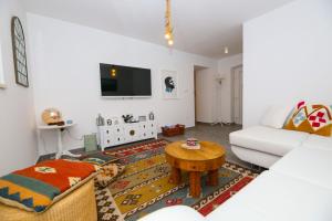 a living room with a couch and a table at Holiday home Ambi for 6, heated pool near Trogir in Trogir