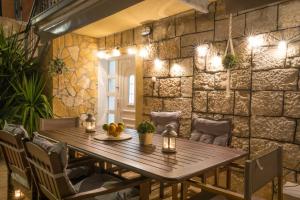 a wooden table in a room with a stone wall at Holiday home Ambi for 6, heated pool near Trogir in Trogir