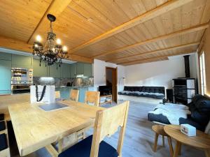 a dining room and living room with a wooden ceiling at Carpe Diem in Wildhaus
