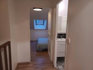- un couloir avec une chambre dotée d'un lavabo et d'un lit dans l'établissement Le Duplex Saint Pry, à Béthune