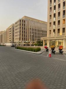 luxury 1 BR studio in Sharjah في الشارقة: مبنى كبير به دراجات نارية متوقفة في موقف للسيارات